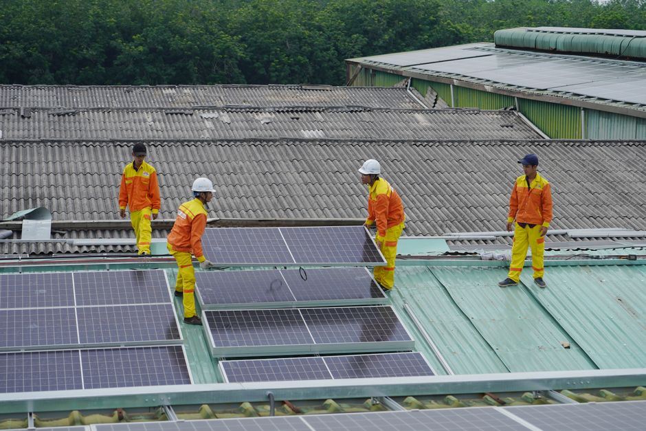 Workers installing solar panels on a residential roof